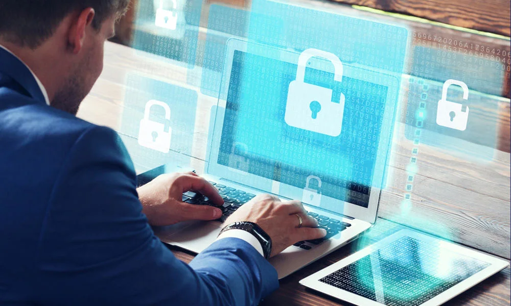 Data security worker on laptop with padlock on screen